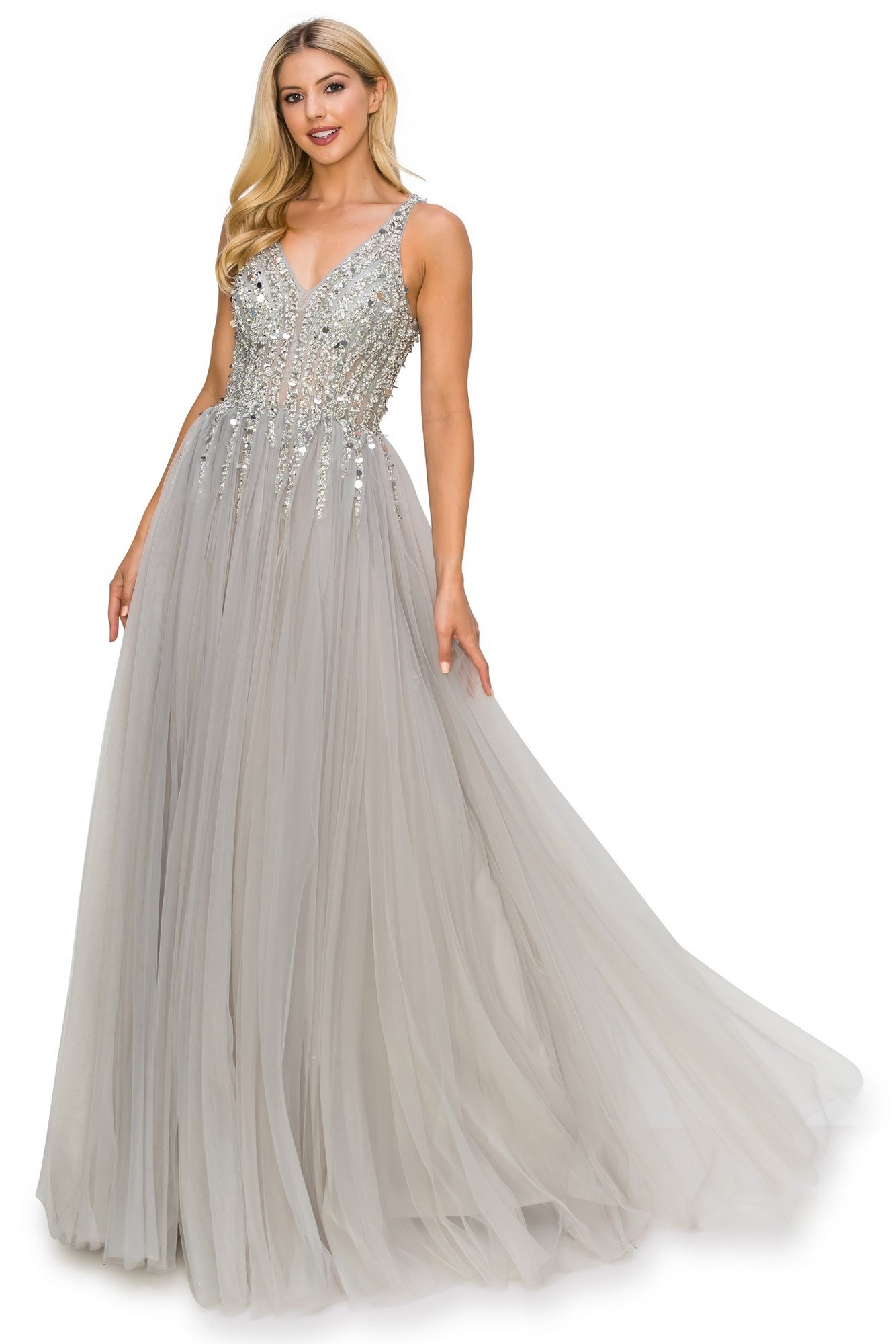 A woman wears the Long Tulle Prom Ball Gown with Sequins 8034J, featuring a sequined v-neck bodice and flowing tulle skirt, as she gracefully holds out part of her shimmering plus size gown.